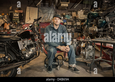 Mechaniker in seiner Garage, die Umwandlung von Gas angetriebene Motorräder zu Bio-Diesel Stockfoto