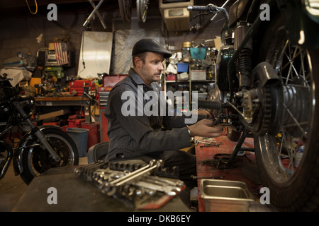 Mechaniker in seiner Garage, die Umwandlung von Gas angetriebene Motorräder zu Bio-Diesel Stockfoto