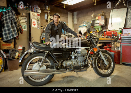 Mechaniker in seiner Garage, die Umwandlung von Gas angetriebene Motorräder zu Bio-Diesel Stockfoto