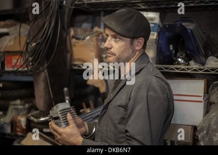 Mechaniker in seiner Garage, die Umwandlung von Gas angetriebene Motorräder zu Bio-Diesel Stockfoto