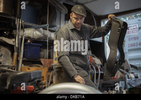 Mechaniker in seiner Garage, die Umwandlung von Gas angetriebene Motorräder zu Bio-Diesel Stockfoto