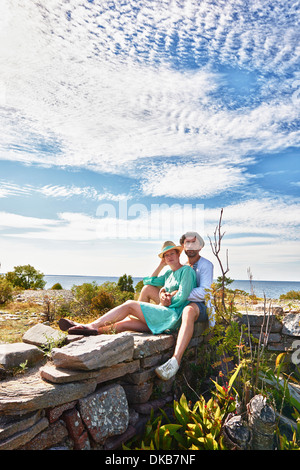 Paar, sitzen auf der Steinmauer, Eggergrund, Schweden Stockfoto