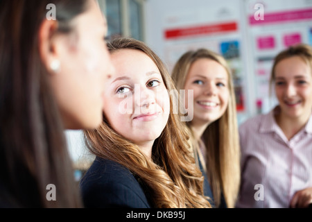 Vier SchülerInnen diskutieren Ideen im Klassenzimmer Stockfoto