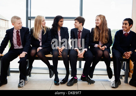 Gruppe von Jugendlichen Schüler sitzen im Korridor Stockfoto