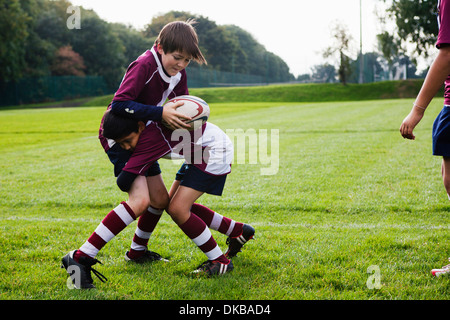Teenager Schuljunge Rugbyteam üben Verteidigung Stockfoto
