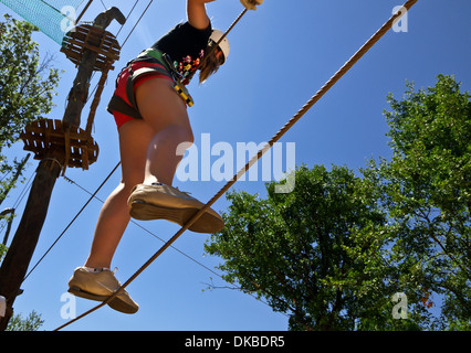 junges Mädchen Klettern mit Sorgfalt im Abenteuerpark Stockfoto