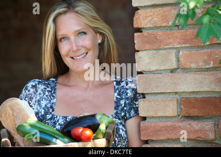 Reife Frau mit Korb von Bio-Lebensmitteln draußen Stockfoto