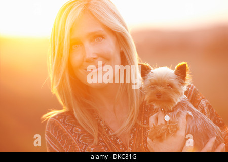 Frau im Feld bei Abenddämmerung Holding Haushund Stockfoto