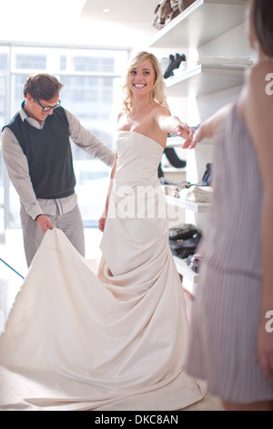 Frau versucht auf Hochzeitskleid Stockfoto