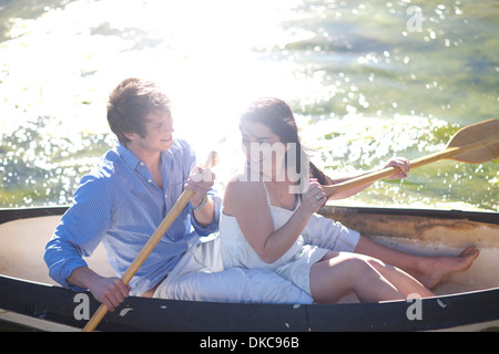 Junges Paar im Ruderboot am Fluss im Sonnenlicht Stockfoto