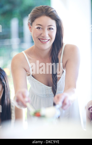 Porträt der jungen Frau Mahlzeit an Freunde Stockfoto