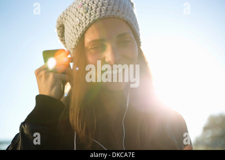 Porträt der jungen Frau mit Kopfhörern Musik hören Stockfoto