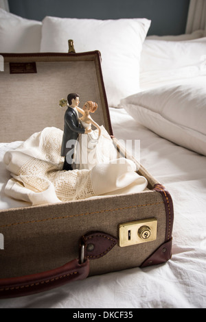 Offenen Koffer auf Bett mit Hochzeit Figuren Stockfoto