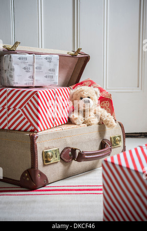 Koffer voller verpackte Geschenke und Teddybär Stockfoto