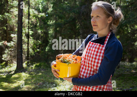 Frau im Wald mit Pilzen im Topf Stockfoto