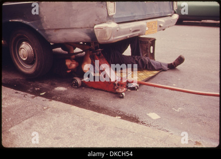 MANN ARBEITET AUF MIETWAGEN IN HELLS KITCHEN, NEW YORK CITY. DIE INNENSTADT IST HEUTE EIN VÖLLIGER WIDERSPRUCH ZU DEN WICHTIGSTEN... 555907 Stockfoto