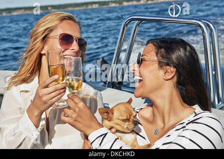 Zwei junge Frauen auf Boot Toasten Wein Stockfoto