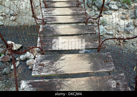 Wackelige Brücke über einen Fluss in der Nähe von Subic, Insel Luzon, Philippinen. Stockfoto