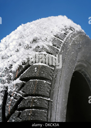 Nahaufnahme von Autoreifen Winter schneebedeckt erschossen auf blauem Hintergrund Stockfoto