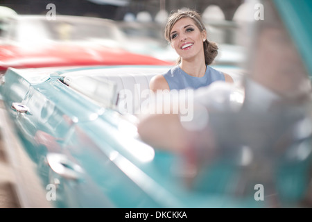Frau genießt Fahrt im rückseitigen Sitz der Oldtimer Cabrio Stockfoto