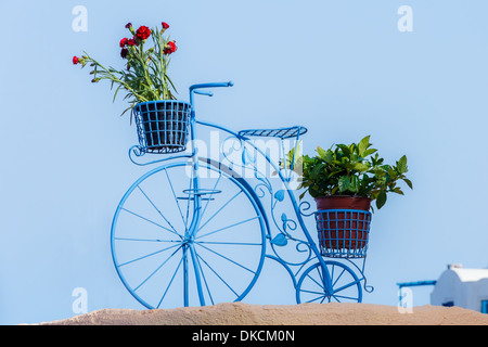 Schöne dekorative Fahrrad in Oia, Santorini, Griechenland mit Töpfe mit Blumen vor blauem Himmel Stockfoto