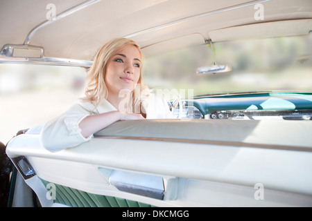 Frau sitzt seitlich im Oldtimer Stockfoto