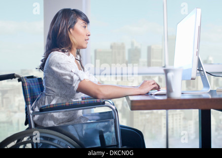 Frau im Rollstuhl mit computer Stockfoto