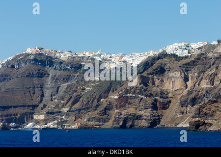 Dorf Imerovigli in vulkanischen Insel Santorin in Griechenland mit Schiffen im Vordergrund fotografiert von einem niedrigen Standpunkt Stockfoto