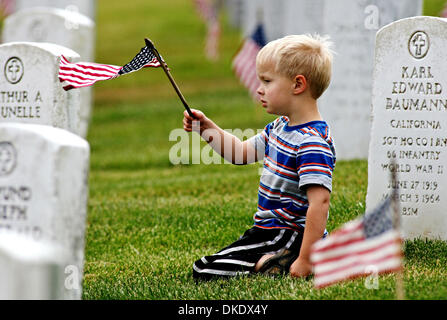 Andrew Wilson, 4, winkt eine Flagge, wie er dazu beigetragen, die kleine amerikanische Flaggen auf den Grabsteinen an der Golden Gate National Cemetery in San Bruno Samstag, 26. Mai 2007. (John Green/San Mateo County Times) Stockfoto