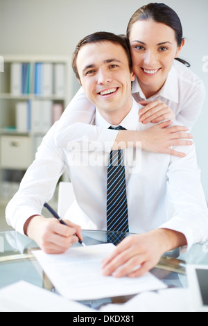 Porträt von glücklich Geschäftsfrau umarmen ihre Kollegin im Büro und beide Blick in die Kamera Stockfoto