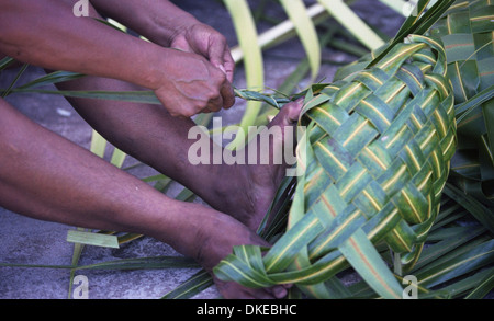 Eine polynesische Frauen flechten Körbe mit Materialien aus der Kokospalme. Stockfoto