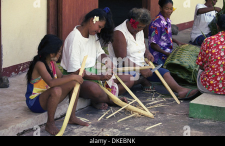 Eine Gruppe von polynesischen Frauen flechten Körbe mit Materialien aus der Kokospalme. Stockfoto