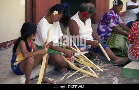 Eine Gruppe von polynesischen Frauen flechten Körbe mit Materialien aus der Kokospalme. Stockfoto