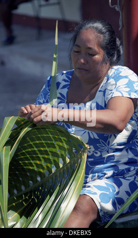 Eine polynesische Frauen flechten Körbe mit Materialien aus der Kokospalme. Stockfoto