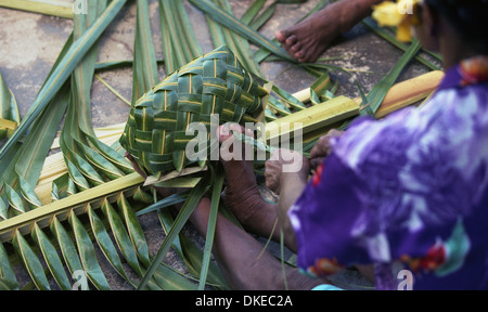 Eine polynesische Frauen flechten Körbe mit Materialien aus der Kokospalme. Stockfoto