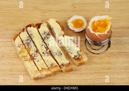 Weich gekochtes Ei und Toast Soldaten auf einem Holzbrett Stockfoto