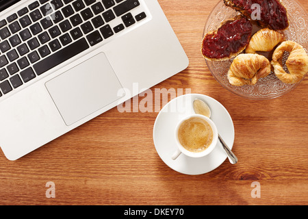 Frühstücken vor Computer am Arbeitsplatz Stockfoto