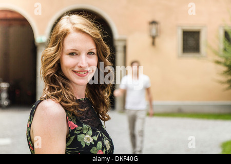 Porträt der jungen Frau, Mann im Hintergrund Stockfoto