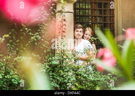 Junges Paar gegen Säule im Garten Stockfoto