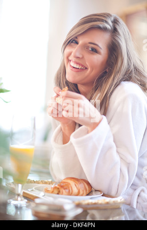 Porträt der jungen Frau im Bett zu frühstücken Stockfoto