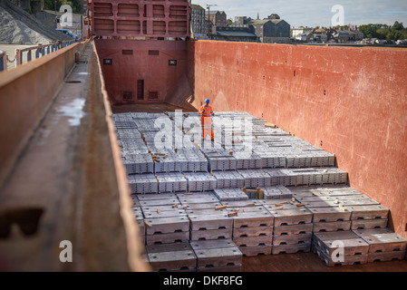 Arbeiter auf Metallbarren in Schiffsluke stehend