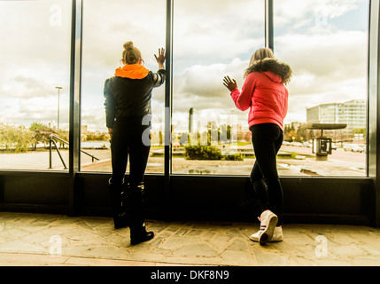 Zwei Freundinnen aus Fenster Stockfoto