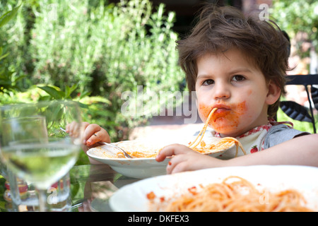 Porträt von chaotisch männliche Kleinkind Spaghetti-Essen Stockfoto