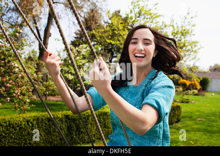 Porträt der jungen Frau genießen Gartenschaukel Stockfoto