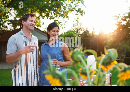 Paar im Garten stehen, Glas Wasser trinken Stockfoto