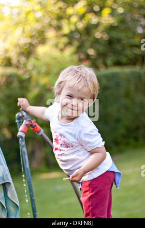 Fröhliches blondes Mädchen im Garten Stockfoto