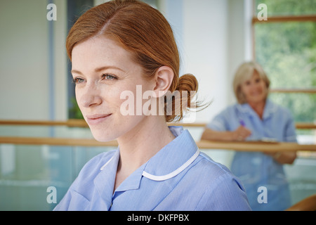 Zwei weibliche Krankenschwestern auf Krankenhaus-Atrium-Balkon Stockfoto