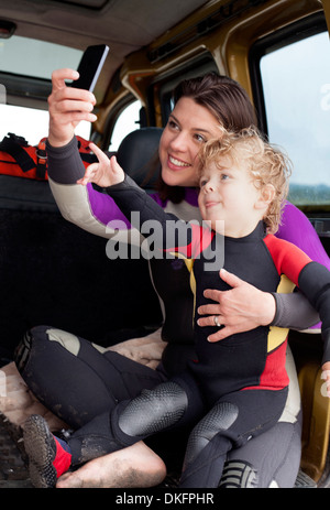 Mutter und Sohn im Auto mit smartphone Stockfoto