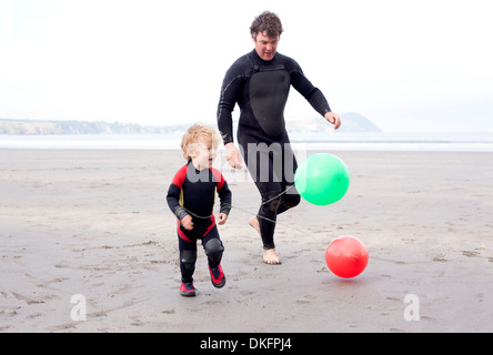 Vater und Sohn spielen mit Luftballons am Strand Stockfoto