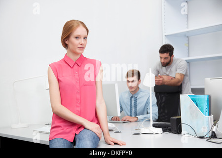 Junge Frau trägt rosa Bluse im Büro Stockfoto